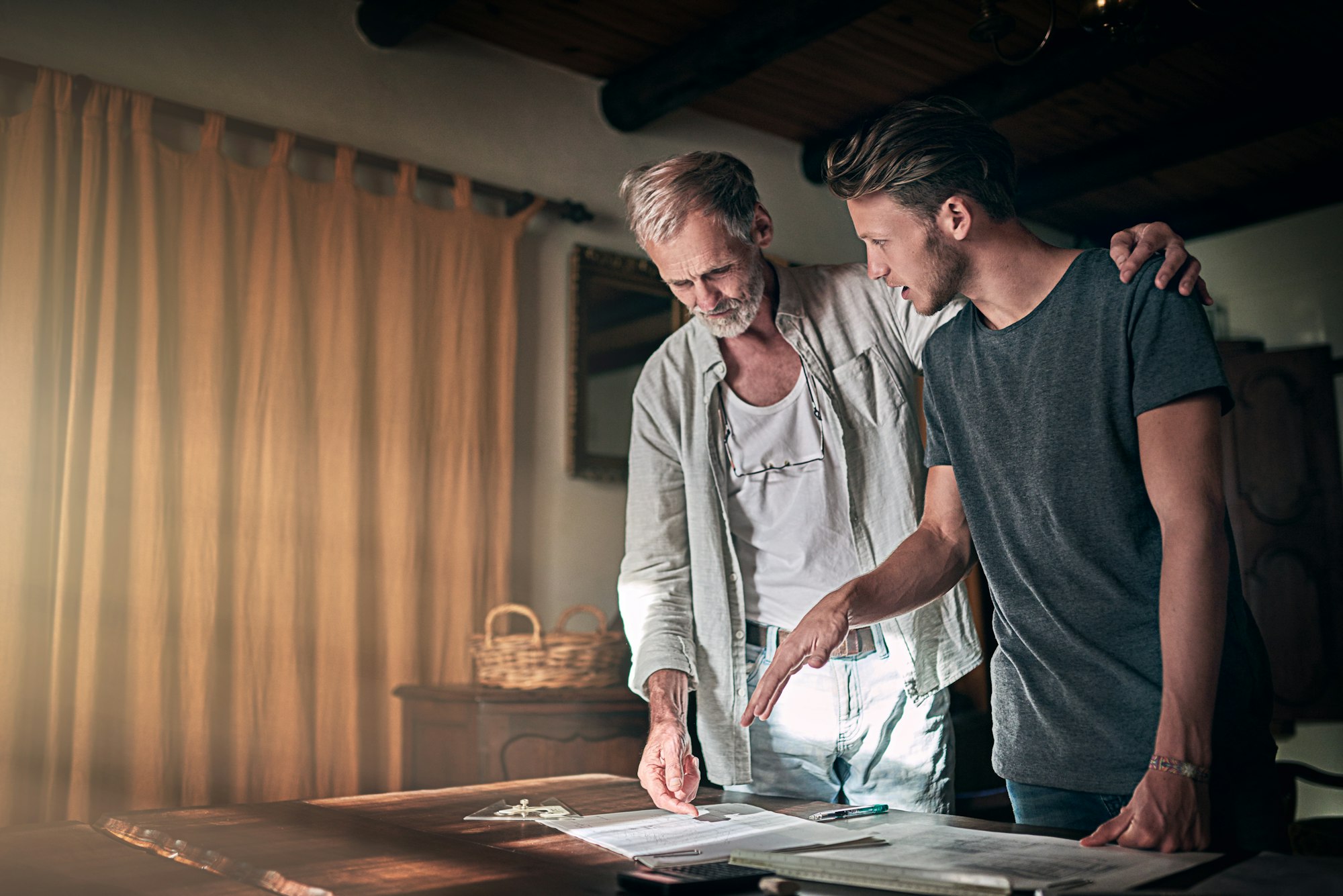 Shot of a father and his son working on a design for their family business at home